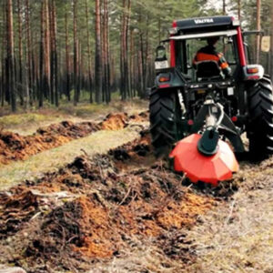 Här ses ett markberedningsaggregat från UOT monterat på en traktor som markbereder i skogen.